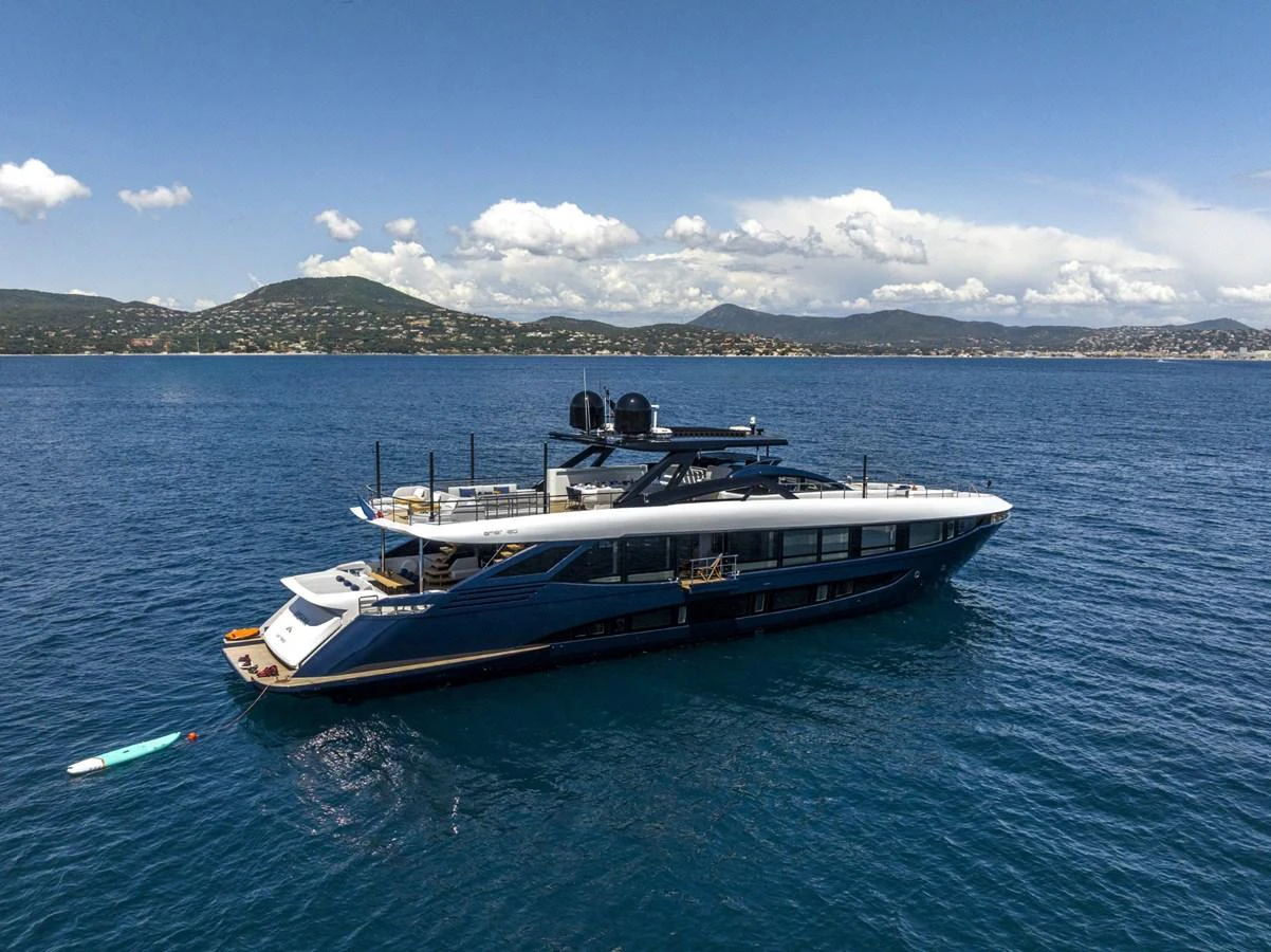 A sleek and modern yacht cruises gracefully on calm blue waters with a scenic coastal backdrop. aboard AMER 120/11 Yacht for Sale