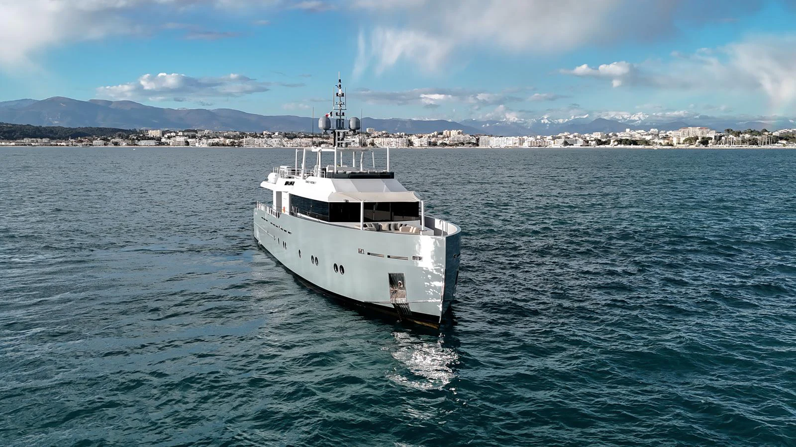 A sleek and modern yacht cruises gracefully on calm waters with a scenic coastal backdrop. aboard ONLY NOW Yacht for Sale