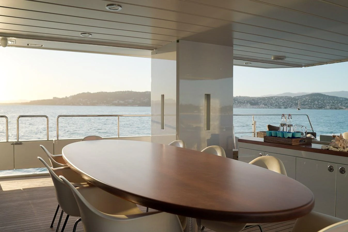The aft deck features a stylish dining area with a large oval table and comfortable seating, perfect for enjoying meals with a view of the sea. aboard ONLY NOW Yacht for Sale