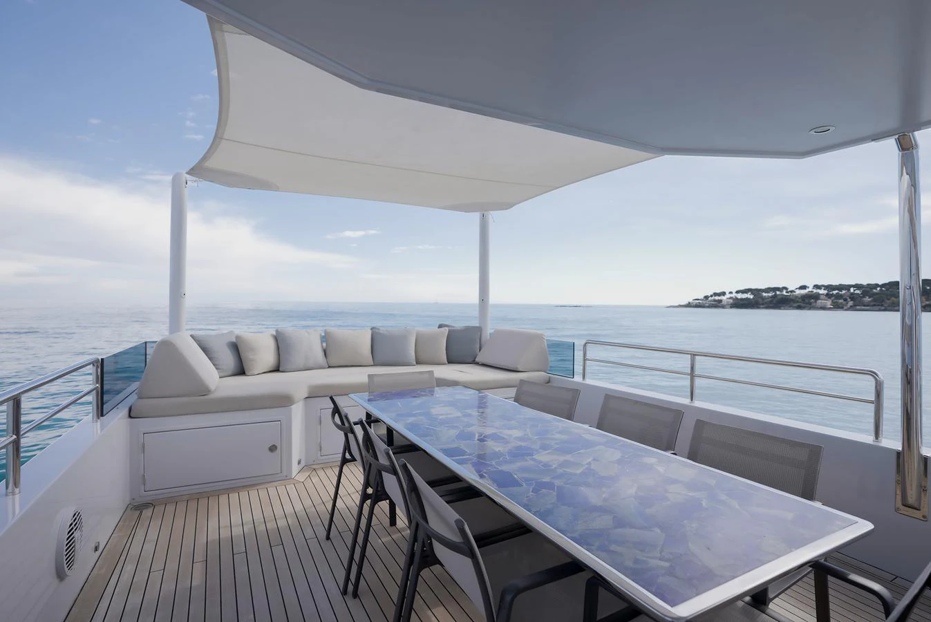 The aft deck features a spacious seating area with a large table, perfect for alfresco dining with stunning ocean views. aboard ONLY NOW Yacht for Sale