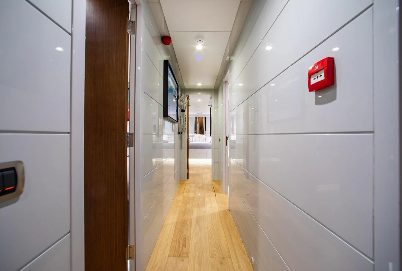 A sleek and modern hallway with wooden flooring and white panel walls. aboard ONLY NOW Yacht for Sale