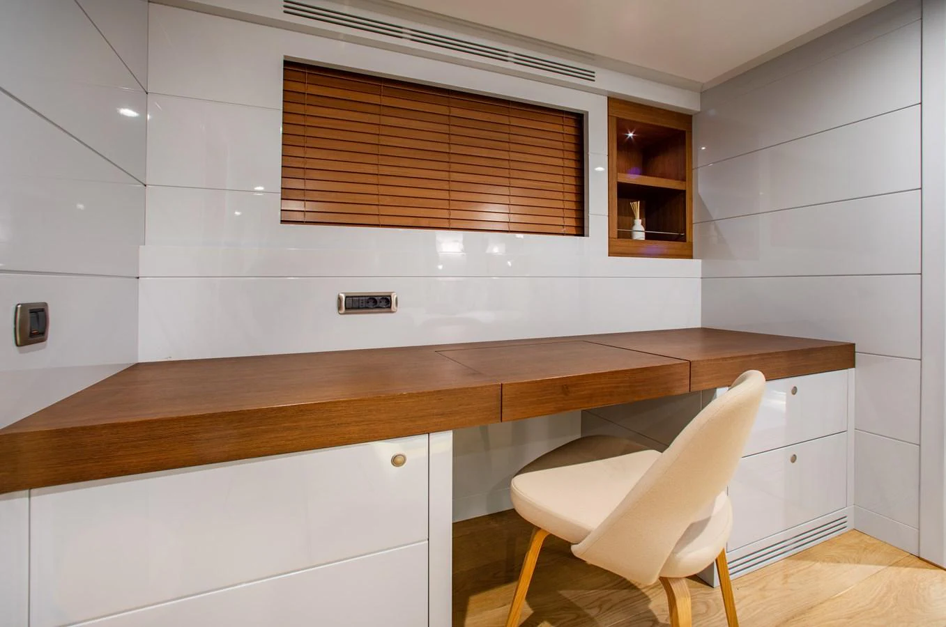A sleek and modern yacht office with a wooden desk and comfortable chair. aboard ONLY NOW Yacht for Sale