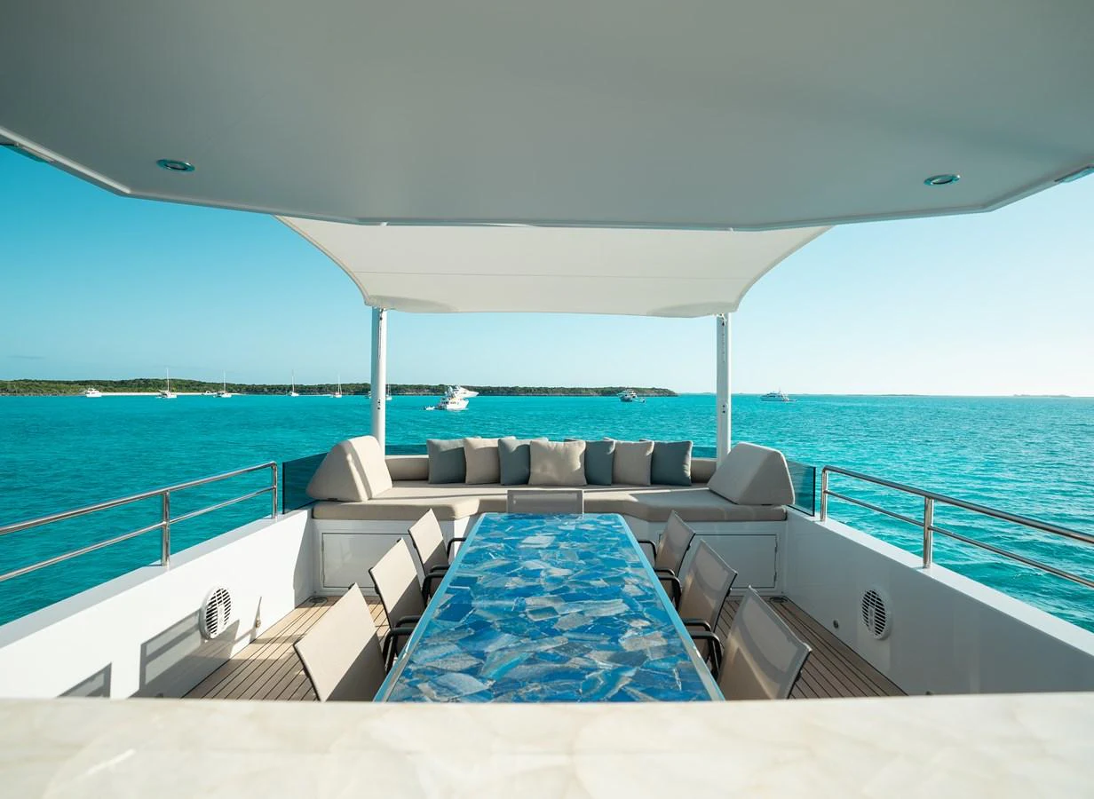 The aft deck features a spacious dining area with a stunning ocean view. aboard ONLY NOW Yacht for Sale