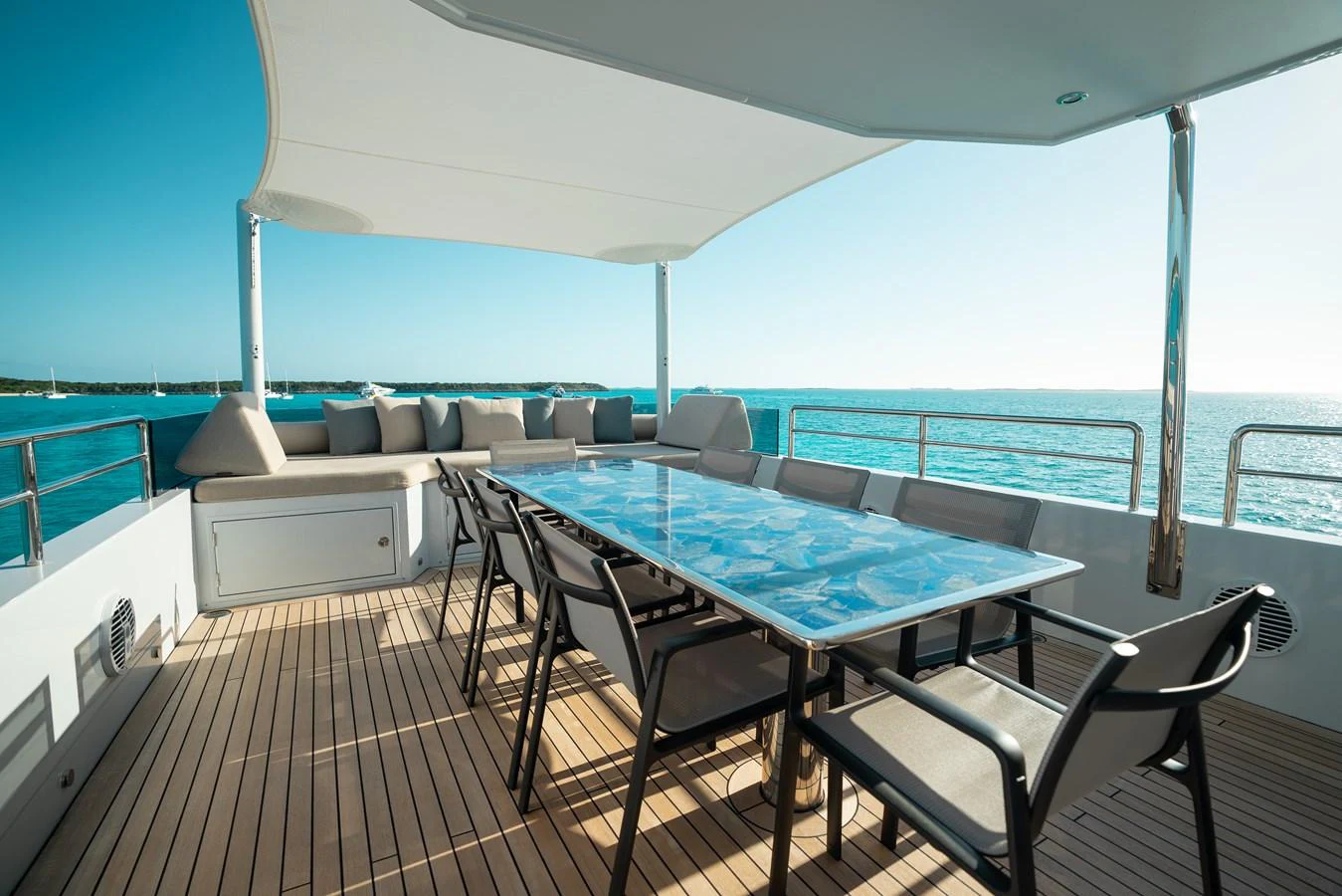 The aft deck features a spacious dining area with a large table and comfortable seating, perfect for alfresco meals with a view of the sea. aboard ONLY NOW Yacht for Sale