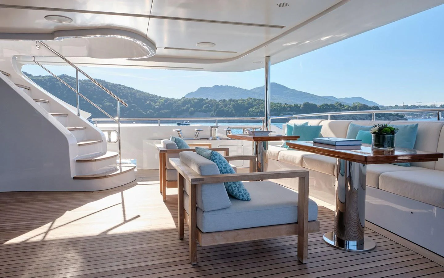 The aft deck features elegant seating with a stunning view of the surrounding landscape. aboard NECHIDA Yacht for Sale