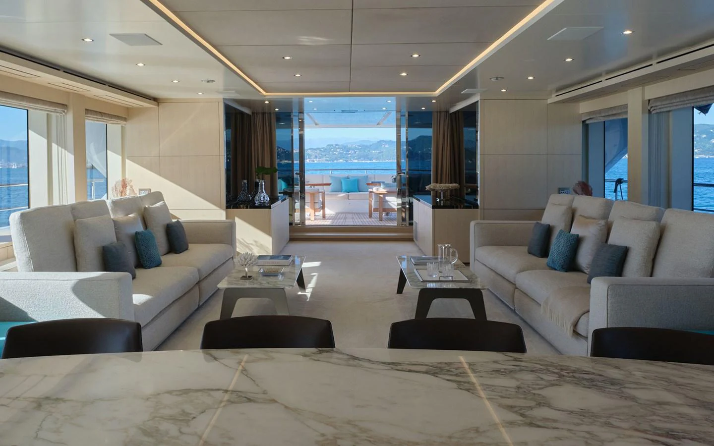 The spacious salon features elegant seating and large windows offering stunning ocean views. aboard NECHIDA Yacht for Sale