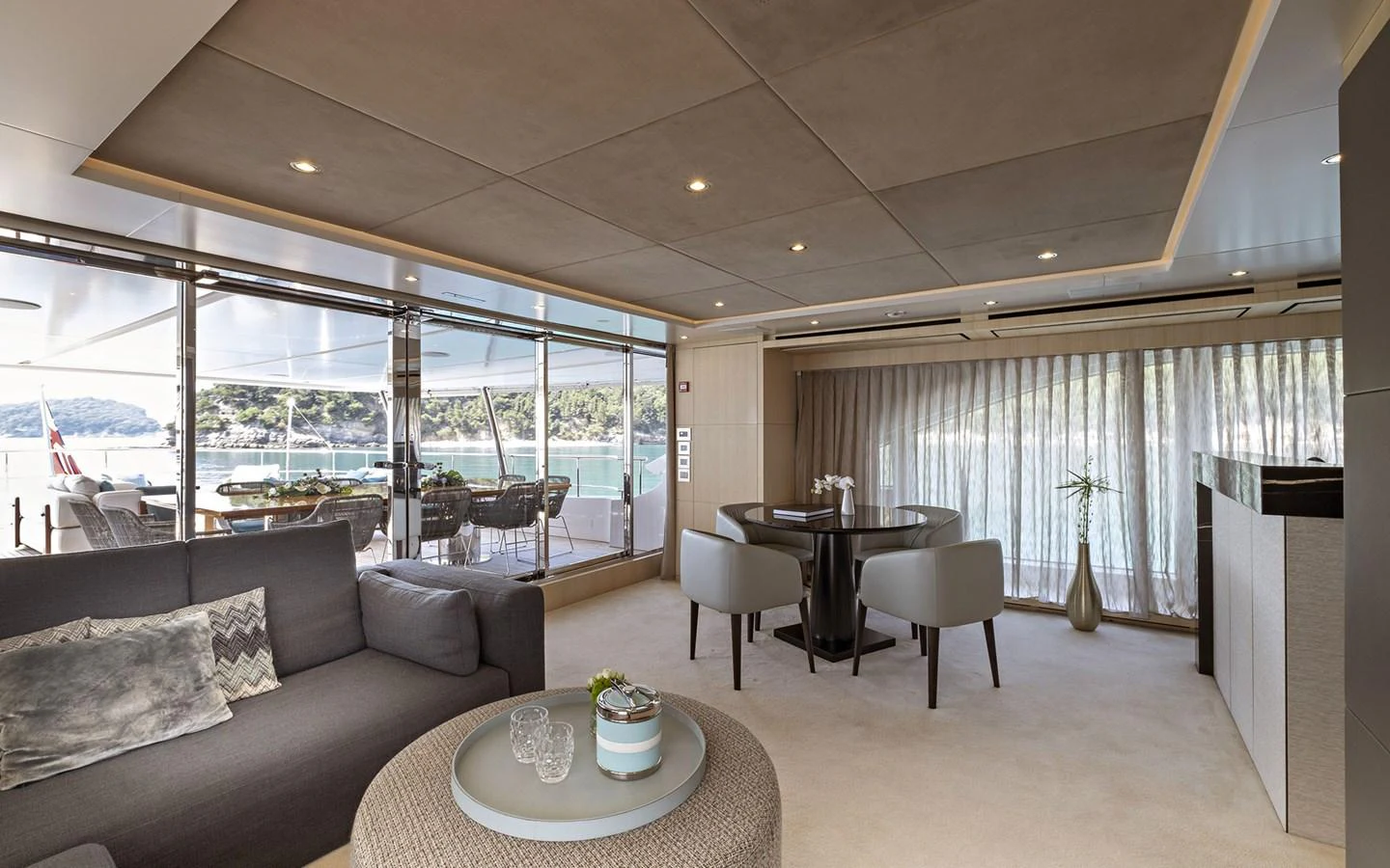 The yacht's salon features a comfortable seating area with modern furnishings and large windows offering scenic views. aboard NECHIDA Yacht for Sale