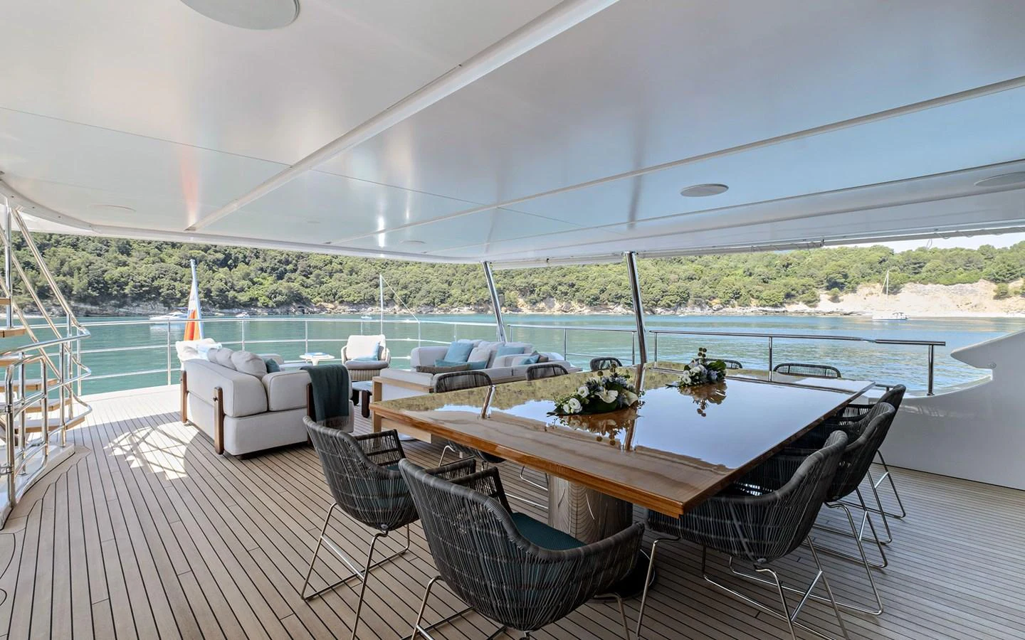 The aft deck features a spacious dining area with a stunning view of the water. aboard NECHIDA Yacht for Sale