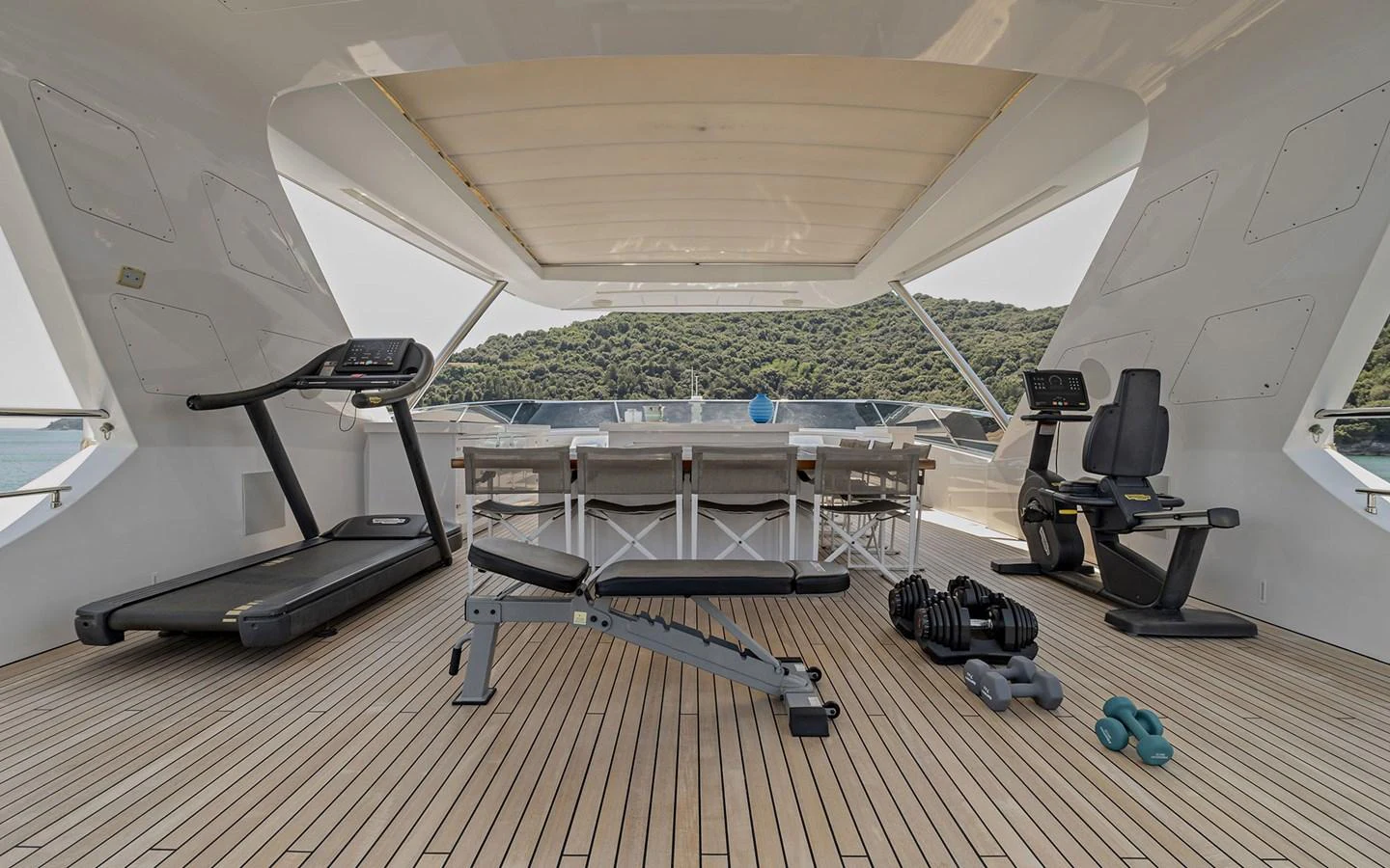 The yacht features a well-equipped gym with modern fitness equipment and a scenic view. aboard NECHIDA Yacht for Sale