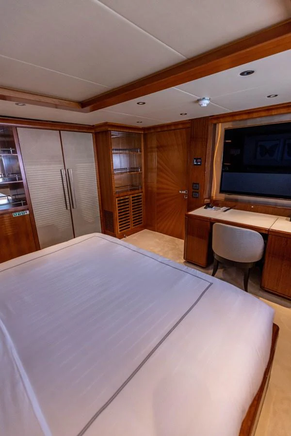 A luxurious stateroom featuring elegant wood finishes and a comfortable bed. aboard ATLANTIS Yacht for Sale
