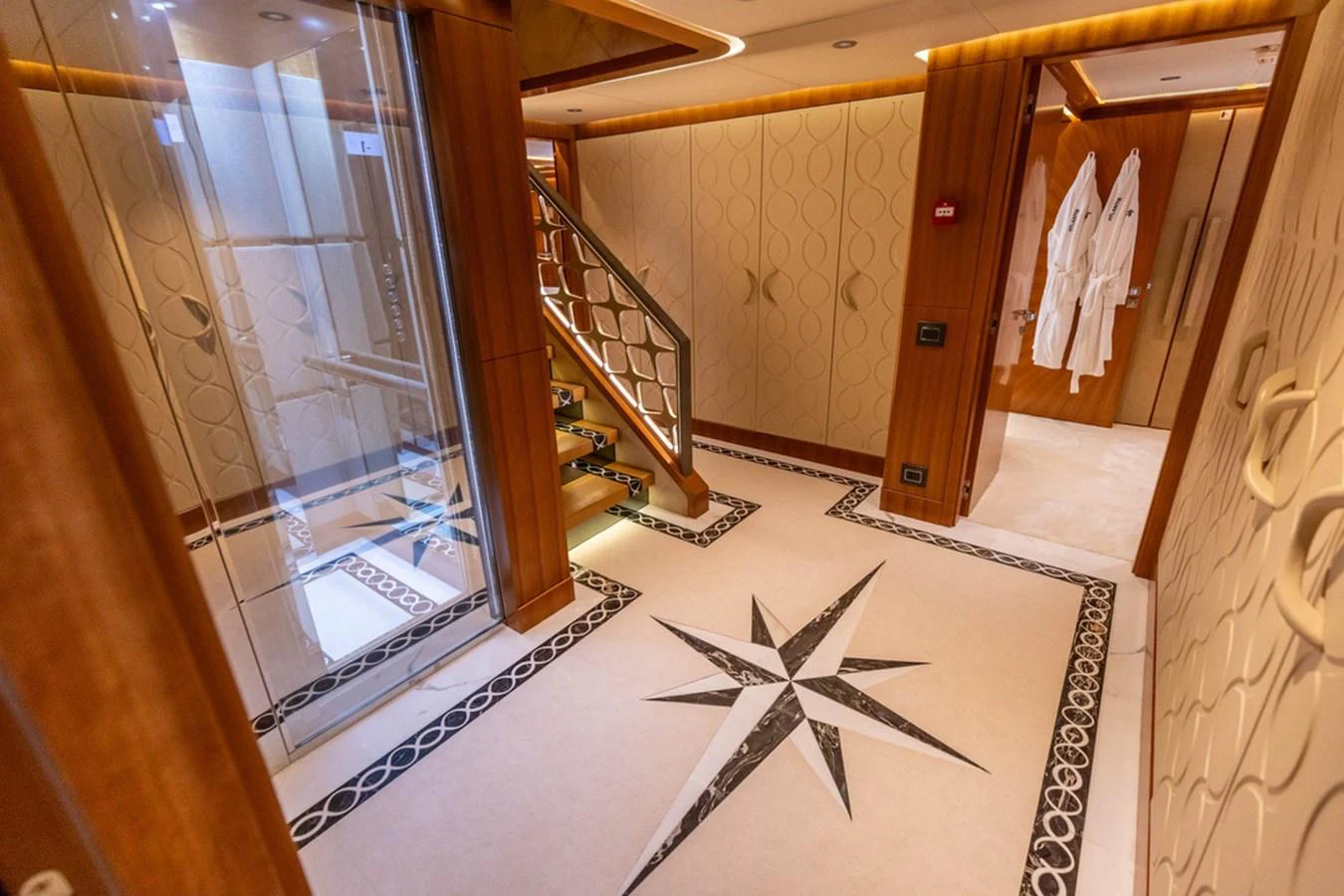 The yacht's interior features a luxurious hallway with intricate flooring and elegant wood finishes. aboard ATLANTIS Yacht for Sale