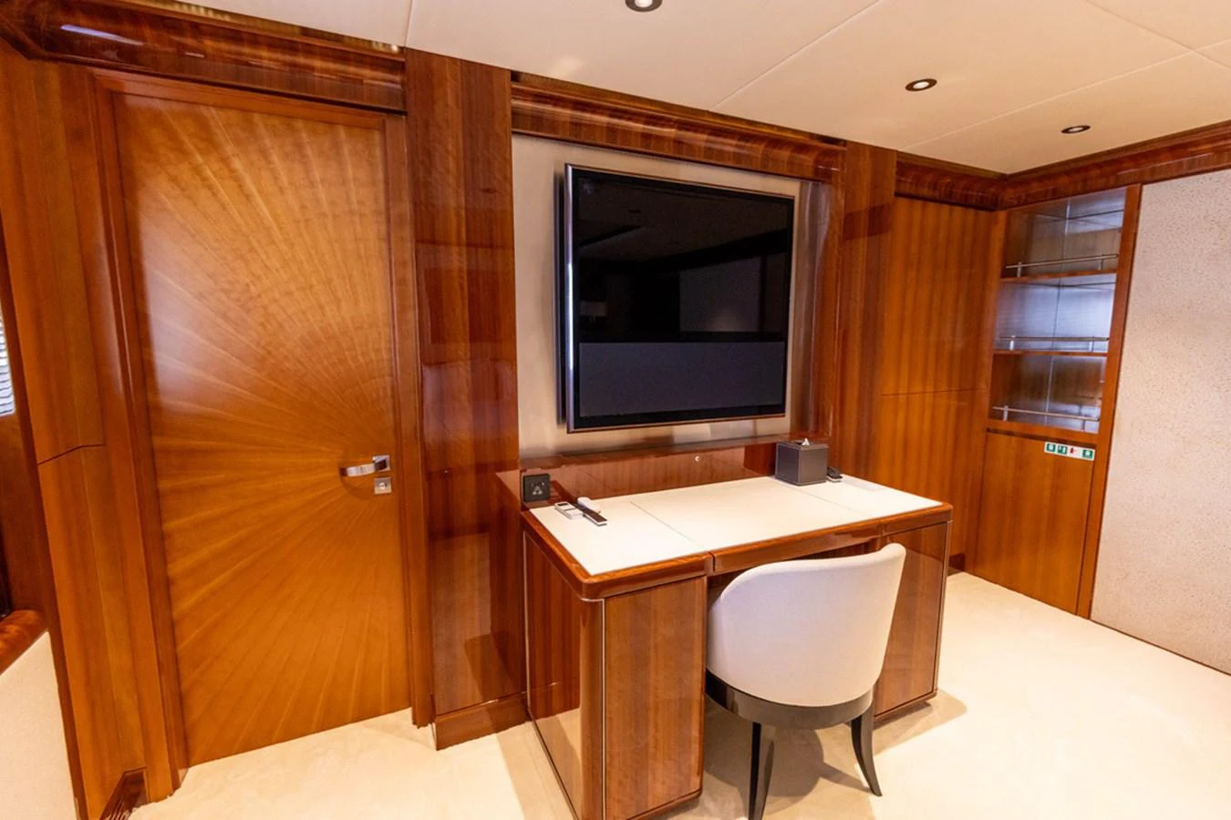 The yacht's office features elegant wood paneling and a large flat-screen TV. aboard ATLANTIS Yacht for Sale