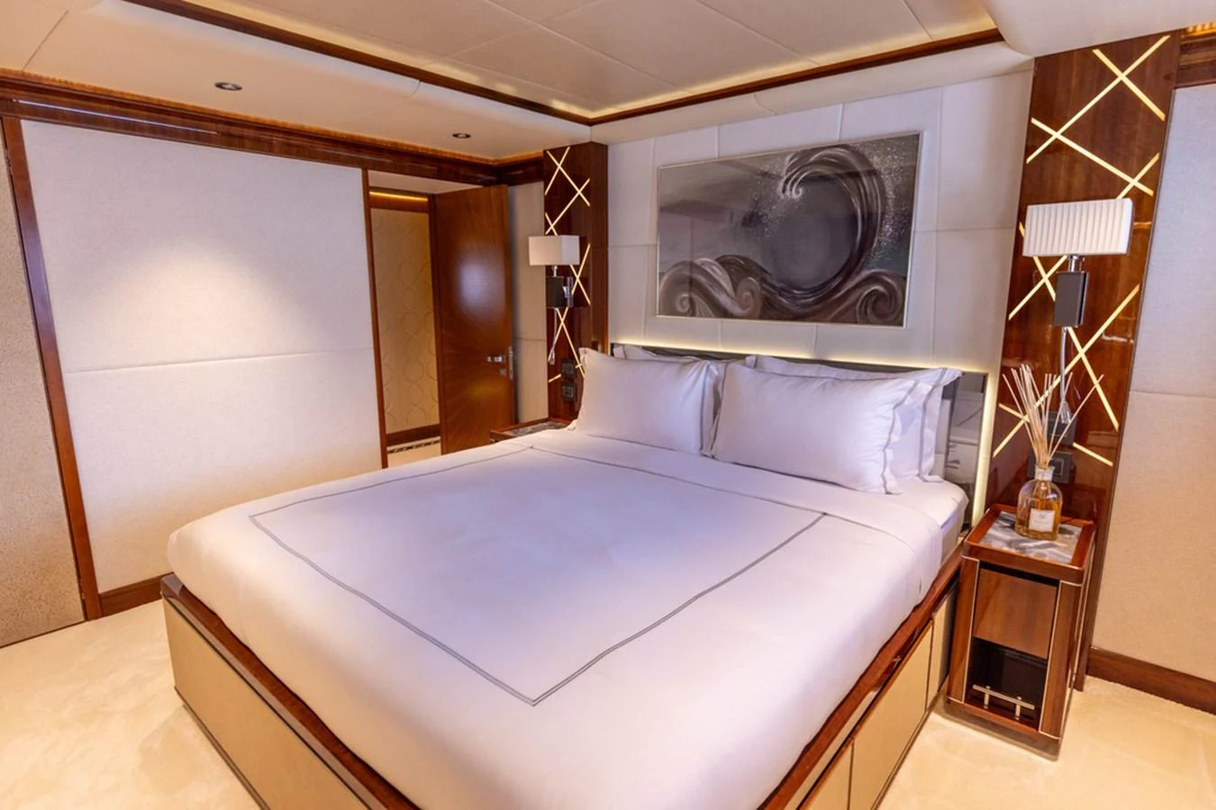The stateroom features a luxurious bed with elegant decor and ambient lighting. aboard ATLANTIS Yacht for Sale