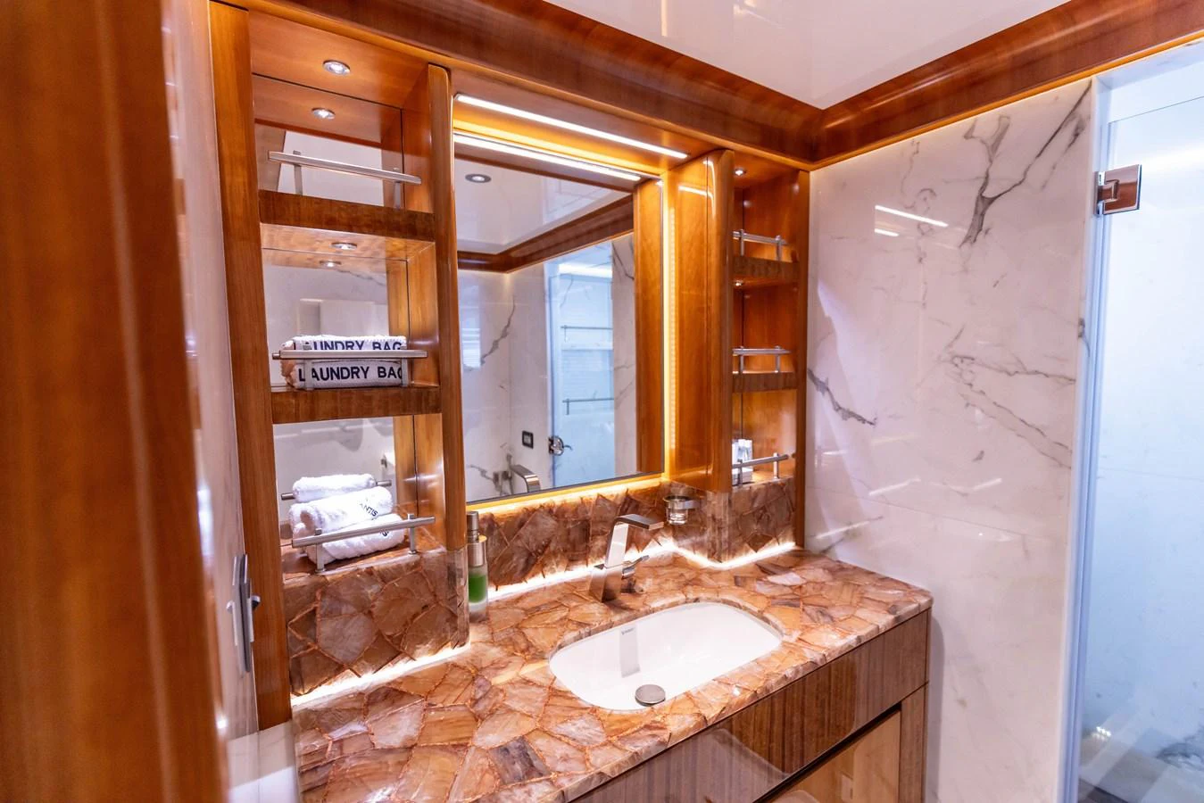 The yacht's bathroom features luxurious marble surfaces and warm wood accents. aboard ATLANTIS Yacht for Sale