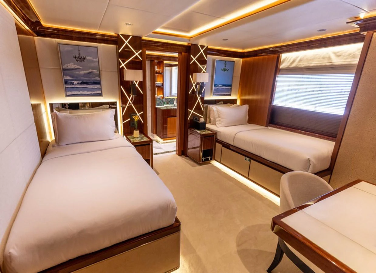 The guest stateroom offers a luxurious and comfortable space with twin beds and elegant decor. aboard ATLANTIS Yacht for Sale