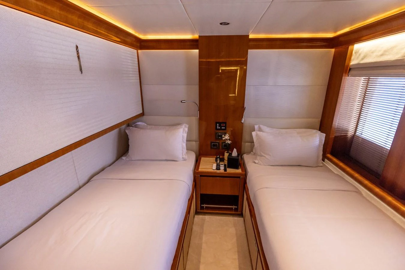 The twin stateroom offers a cozy and inviting space with two single beds and warm wood accents. aboard ATLANTIS Yacht for Sale
