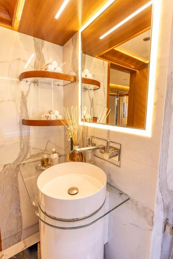 A luxurious yacht bathroom featuring a modern sink and elegant lighting. aboard ATLANTIS Yacht for Sale