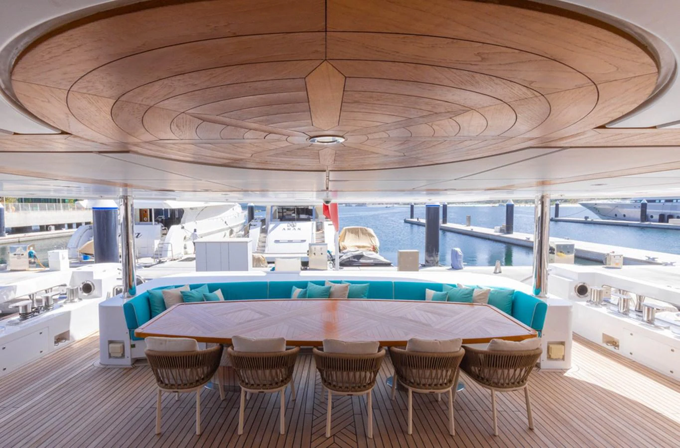 The aft deck features a spacious dining area with a large wooden table and comfortable seating, perfect for alfresco meals. aboard ATLANTIS Yacht for Sale