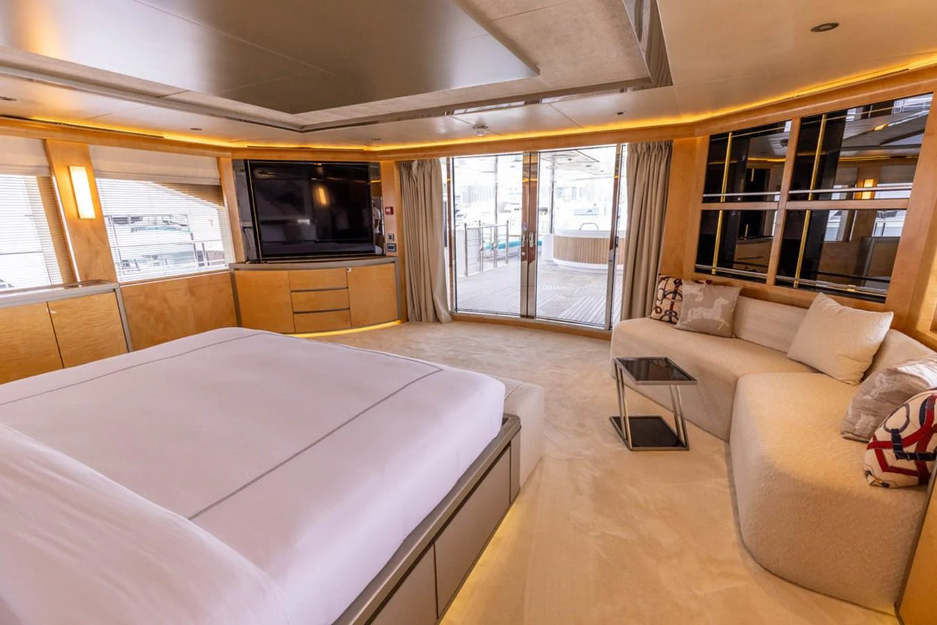 The master stateroom features a spacious layout with a large bed, cozy seating area, and ample natural light. aboard ATLANTIS Yacht for Sale