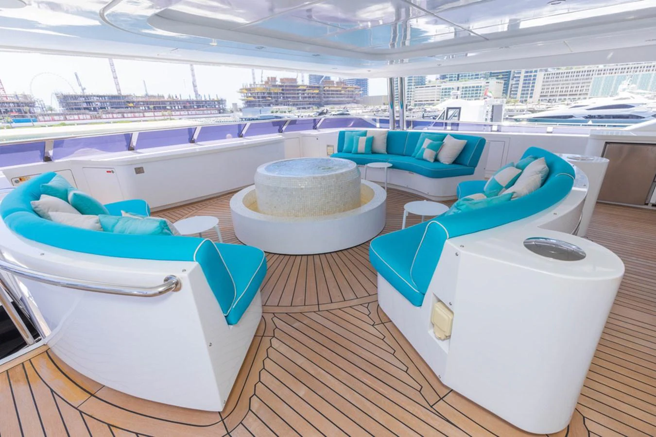 The aft deck features a spacious seating area with vibrant turquoise cushions and a central table, perfect for relaxation and socializing. aboard ATLANTIS Yacht for Sale