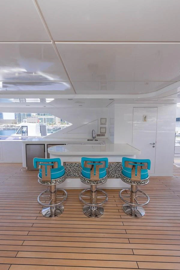 The yacht features a stylish bar area with modern bar stools and a sleek countertop. aboard ATLANTIS Yacht for Sale