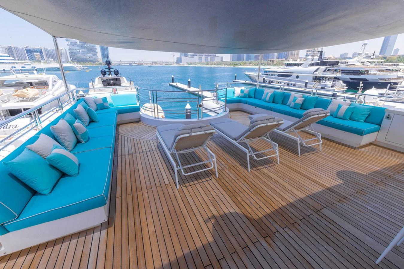 The sundeck offers ample seating with turquoise cushions and sun loungers, perfect for relaxation. aboard ATLANTIS Yacht for Sale