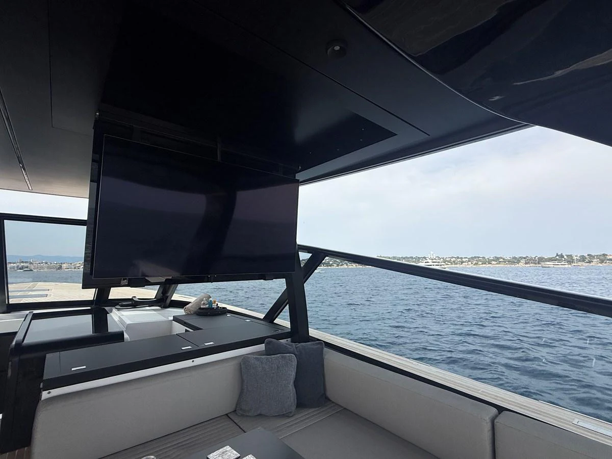 The aft deck features a comfortable seating area with a large TV and scenic views of the water. aboard DUTCH PEARL Yacht for Sale
