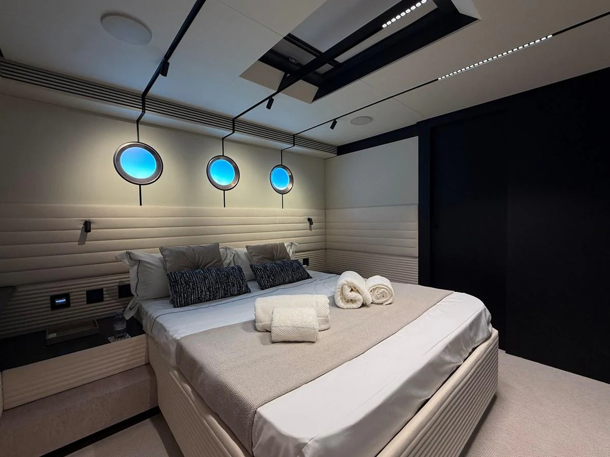 The stateroom features a luxurious bed with plush linens and modern lighting. aboard DUTCH PEARL Yacht for Sale