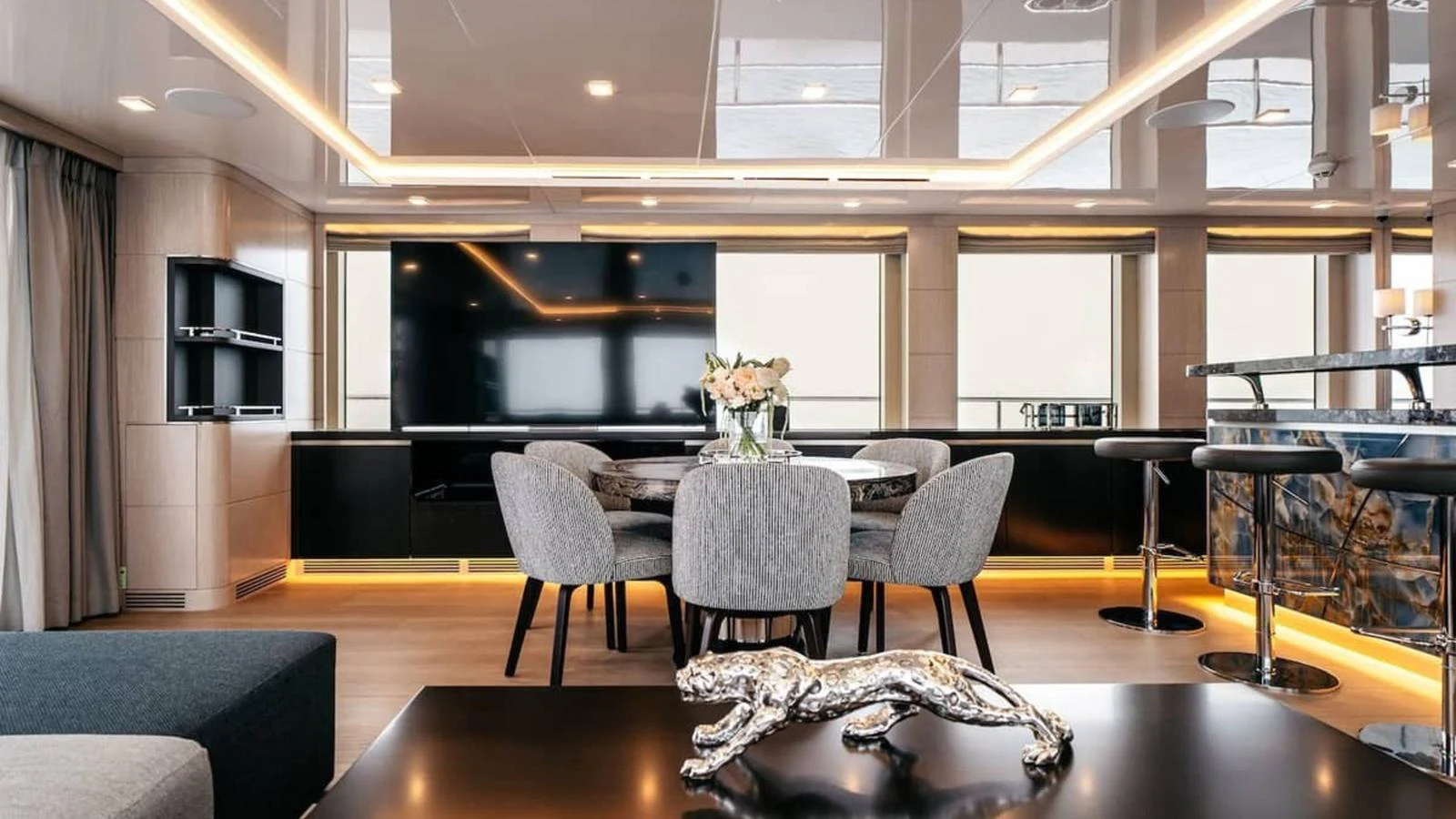 The salon features modern furnishings with a sleek design and ambient lighting. aboard HEEUS Yacht for Sale
