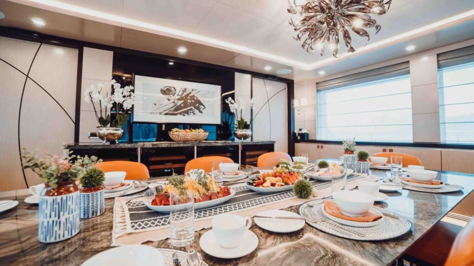 The yacht's dining area features a beautifully set table with elegant decor and ample natural light. aboard HEEUS Yacht for Sale