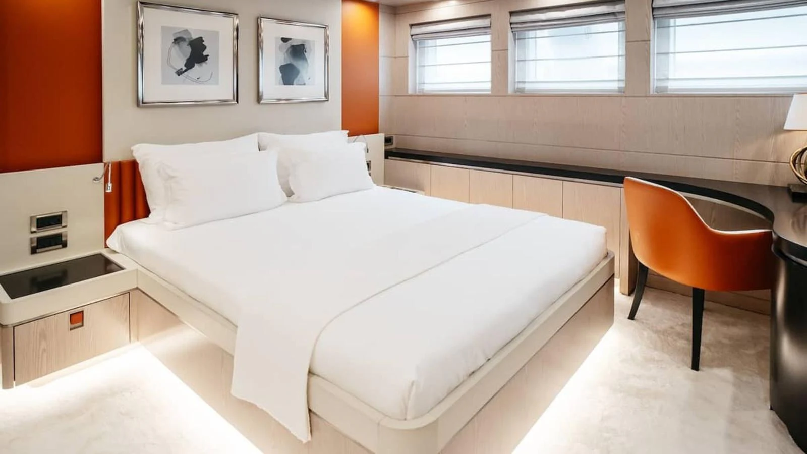 The stateroom features a luxurious bed with modern decor and ambient lighting. aboard HEEUS Yacht for Sale