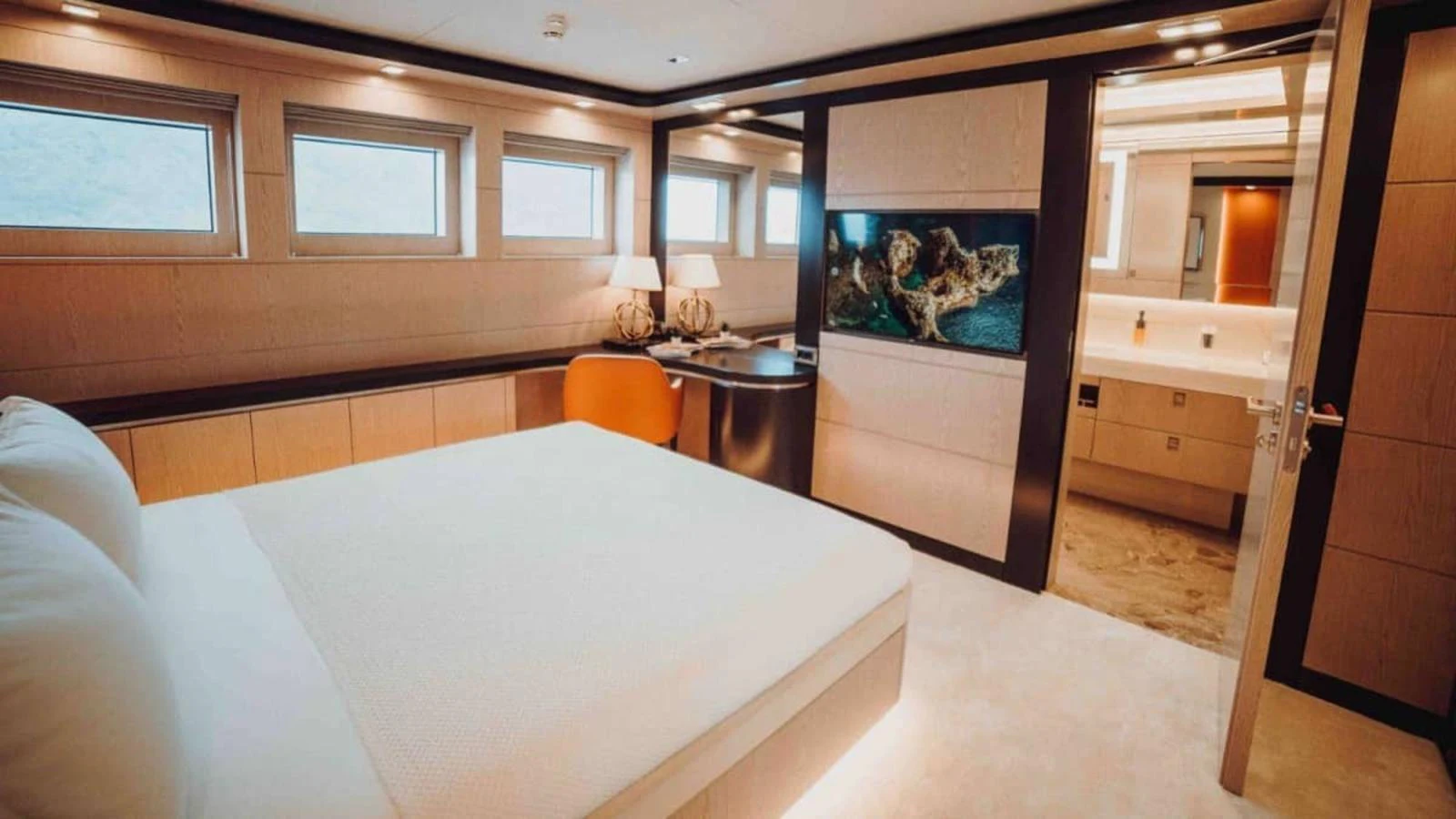 A luxurious stateroom featuring a large bed, modern decor, and ample natural light. aboard HEEUS Yacht for Sale