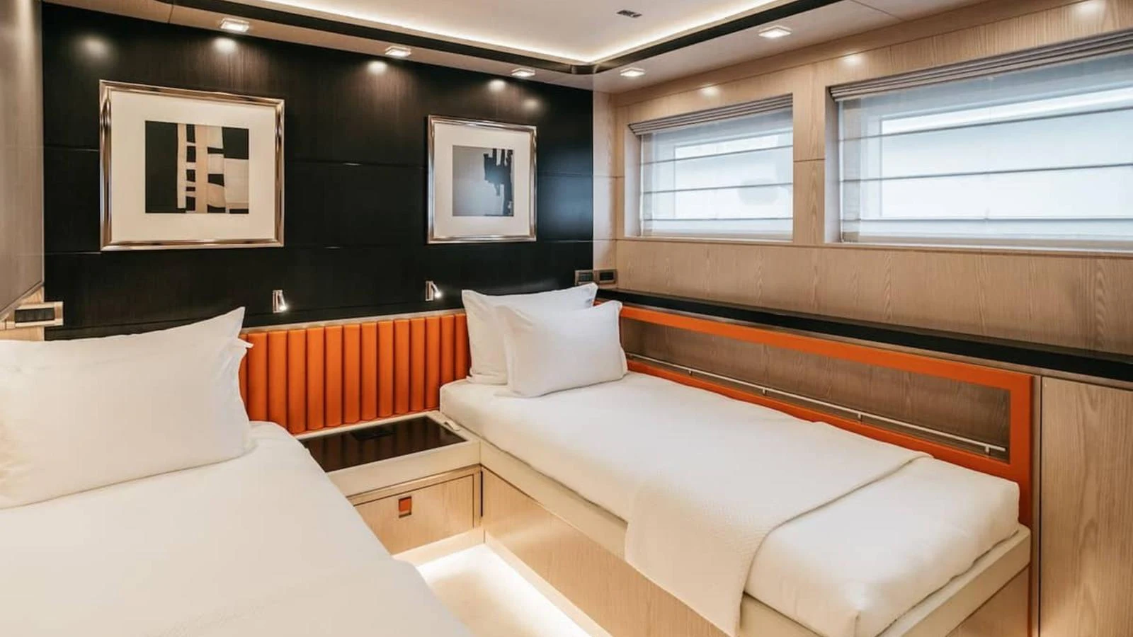 The guest stateroom features twin beds with modern decor and ample natural light. aboard HEEUS Yacht for Sale