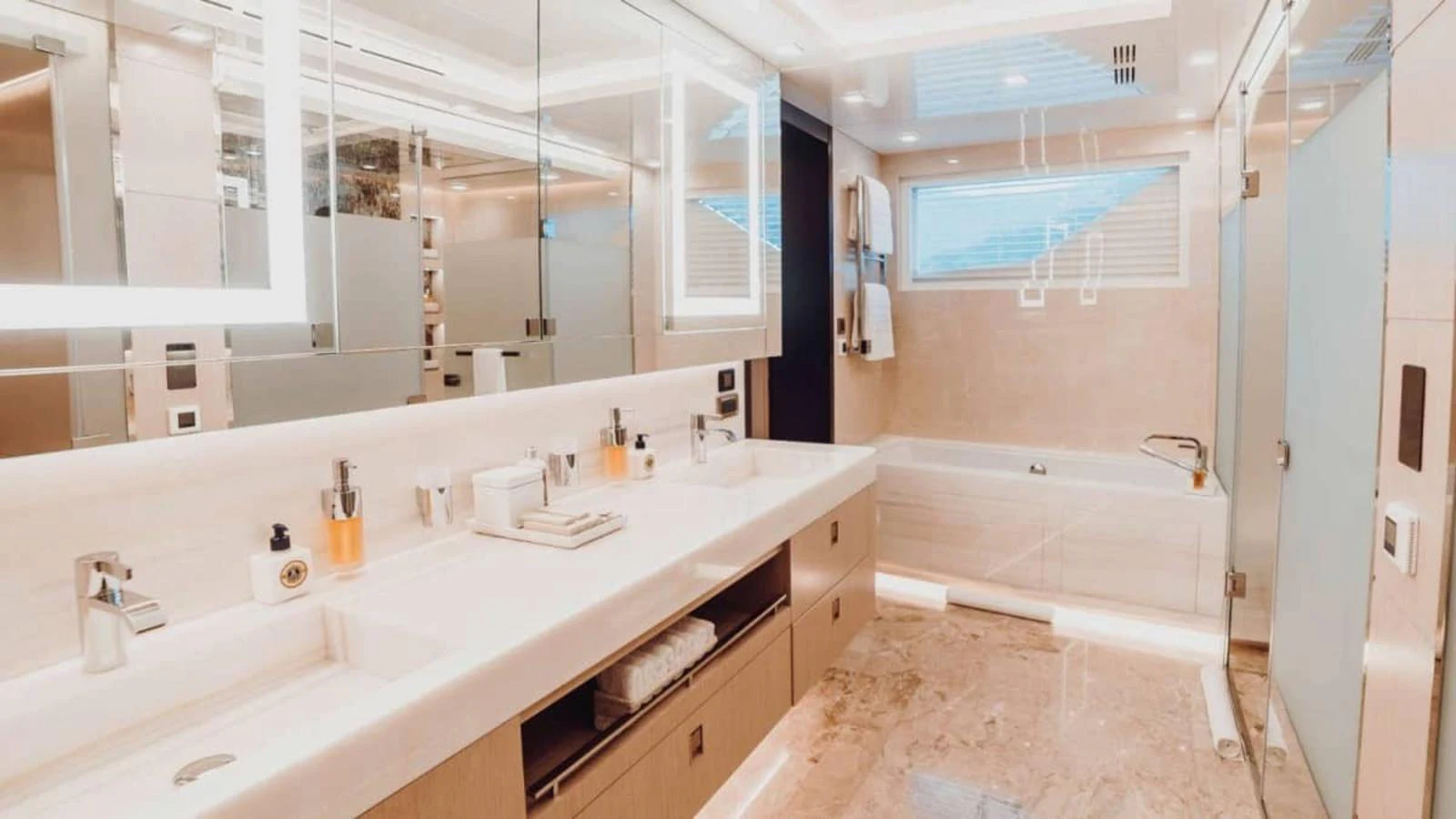 The luxurious bathroom features a spacious layout with dual sinks, a large mirror, and a bathtub. aboard HEEUS Yacht for Sale