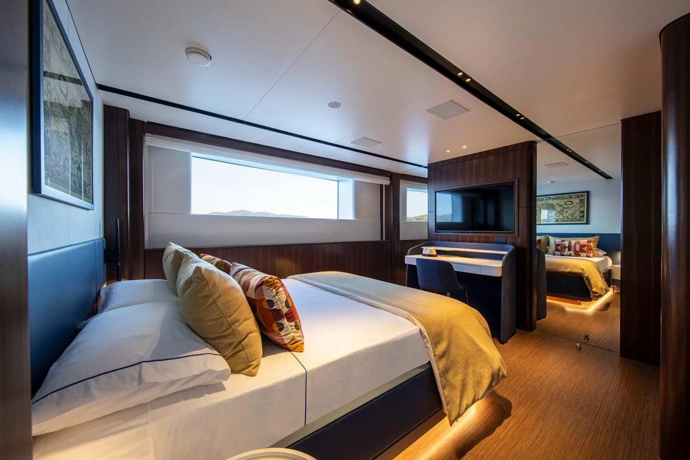 The stateroom features a luxurious bed, elegant decor, and ample natural light. aboard JULES Yacht for Sale