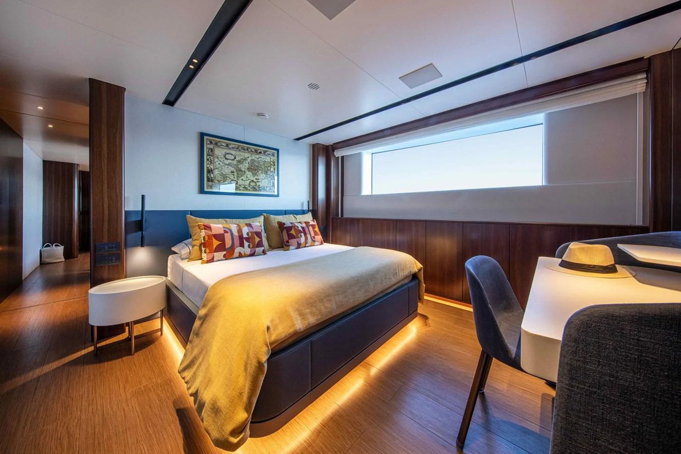 The stateroom features a luxurious bed with ambient lighting and a large window offering natural light. aboard JULES Yacht for Sale
