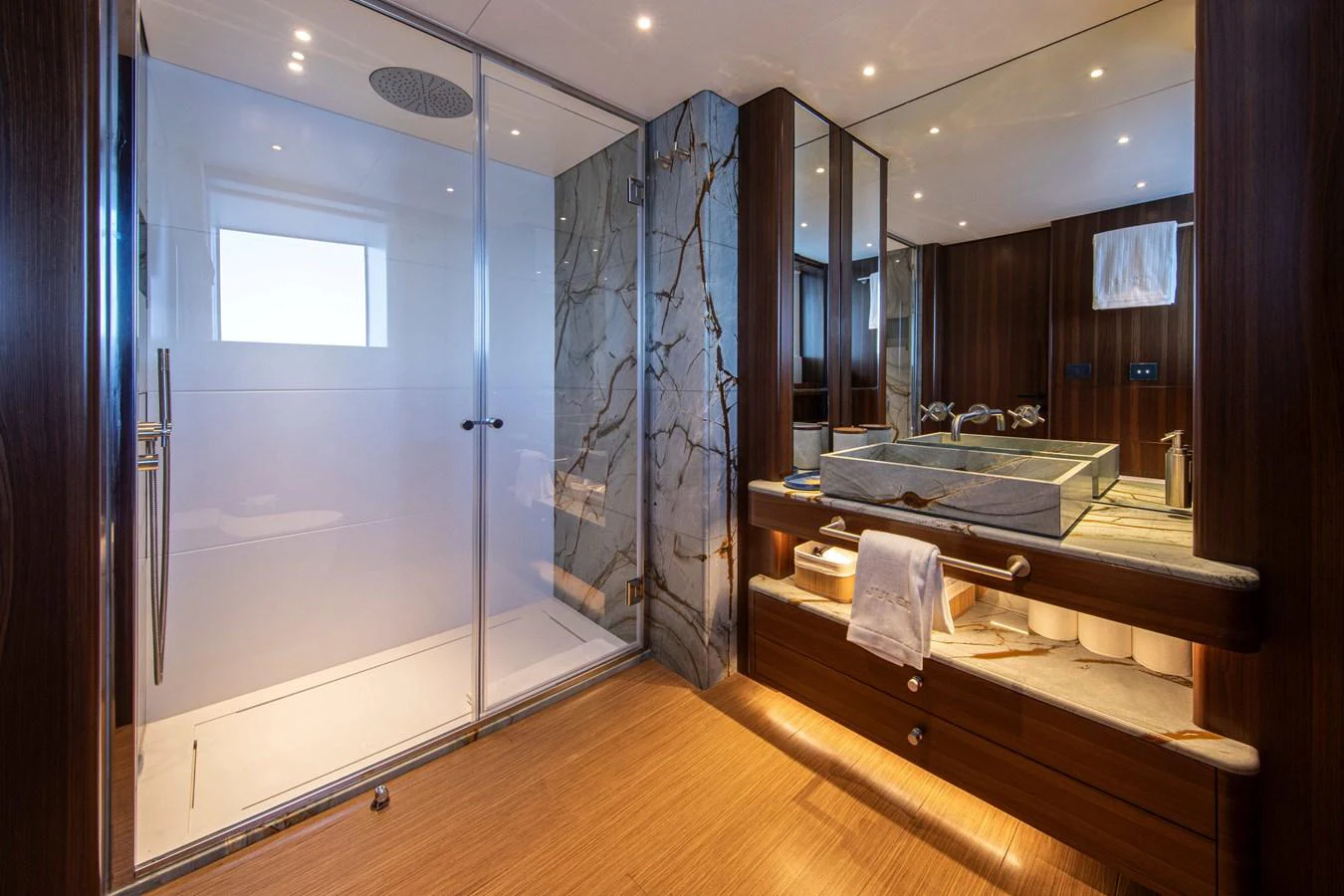 The yacht's bathroom features a spacious shower, elegant marble accents, and modern fixtures. aboard JULES Yacht for Sale