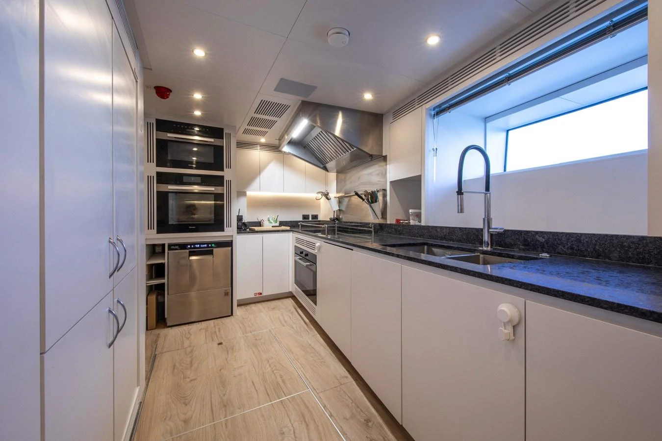 The yacht's galley is modern and well-equipped, featuring sleek cabinetry and high-end appliances. aboard JULES Yacht for Sale
