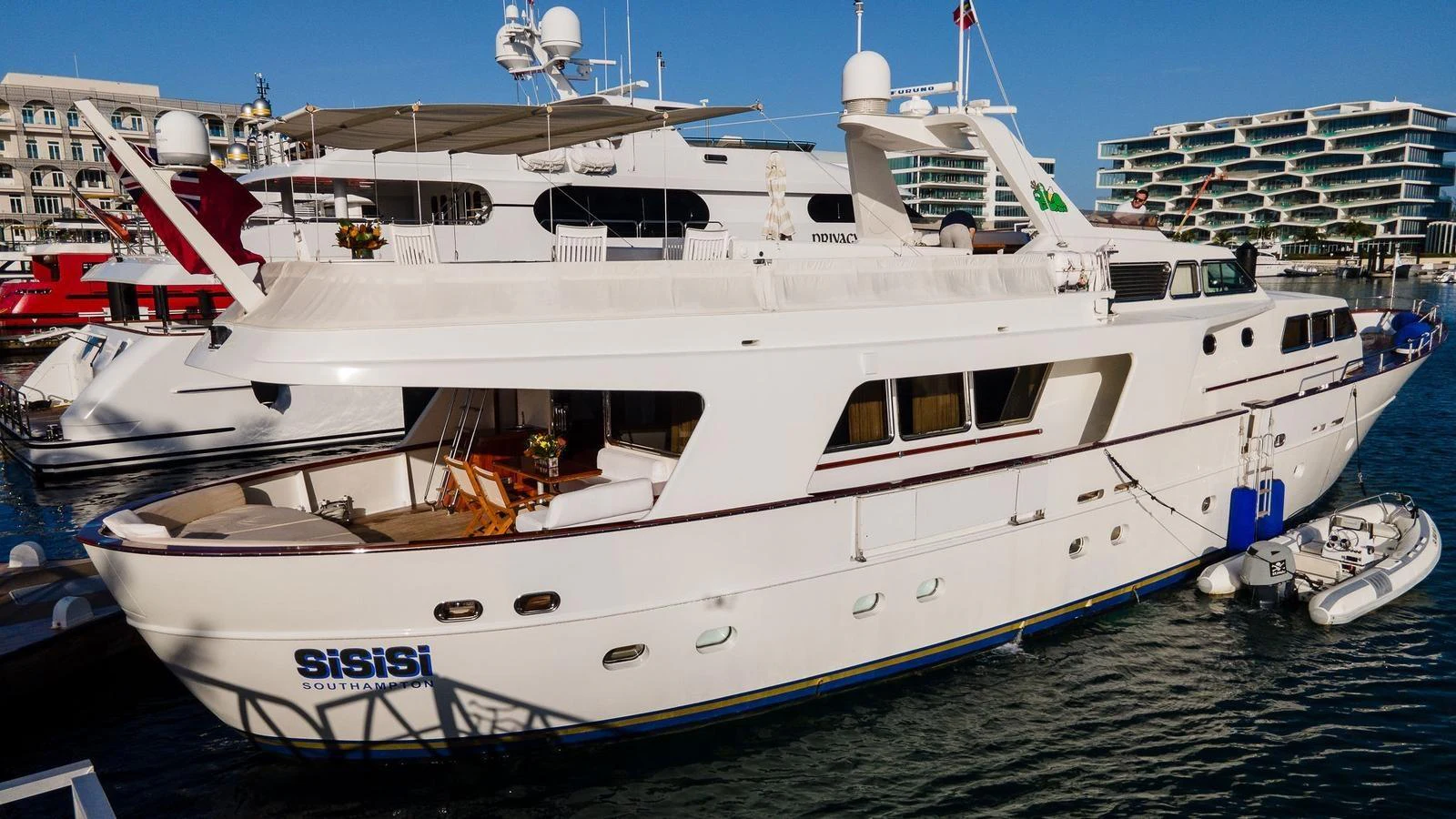 A luxurious yacht is docked at a marina, showcasing its elegant design and spacious decks. aboard SISISI Yacht for Sale