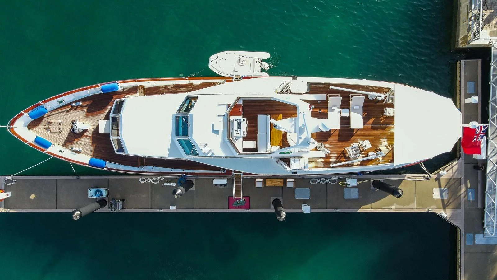 A stunning aerial view of a luxury yacht docked at the marina, showcasing its sleek design and spacious deck areas. aboard SISISI Yacht for Sale