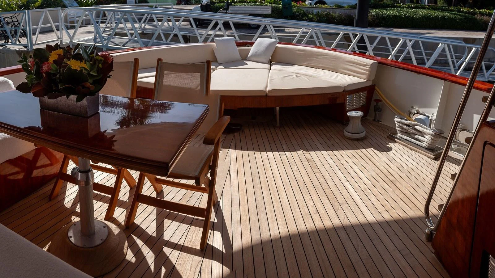 The aft deck features a comfortable seating area with a wooden table and chairs, perfect for outdoor relaxation. aboard SISISI Yacht for Sale
