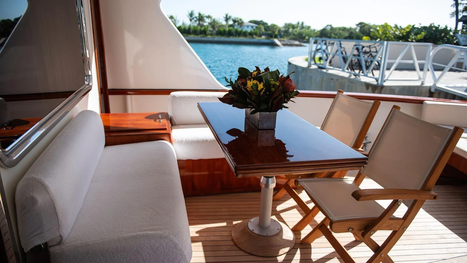 The aft deck features a cozy seating area with a polished wooden table and comfortable chairs, perfect for enjoying the view. aboard SISISI Yacht for Sale