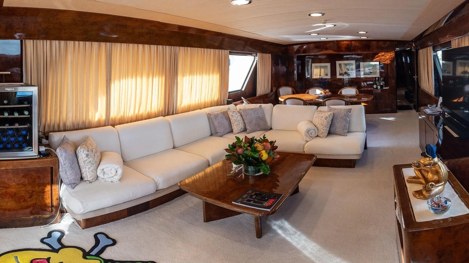 The salon features a spacious seating area with plush white couches and elegant wooden accents. aboard SISISI Yacht for Sale