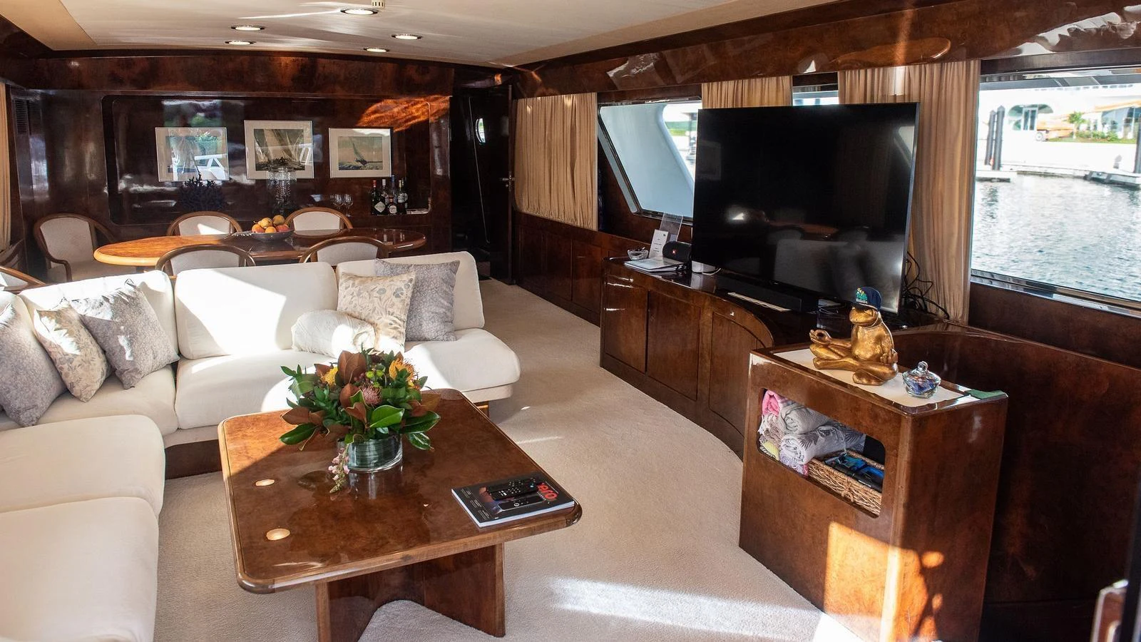 The yacht's salon features elegant wood finishes, plush seating, and a large TV for entertainment. aboard SISISI Yacht for Sale