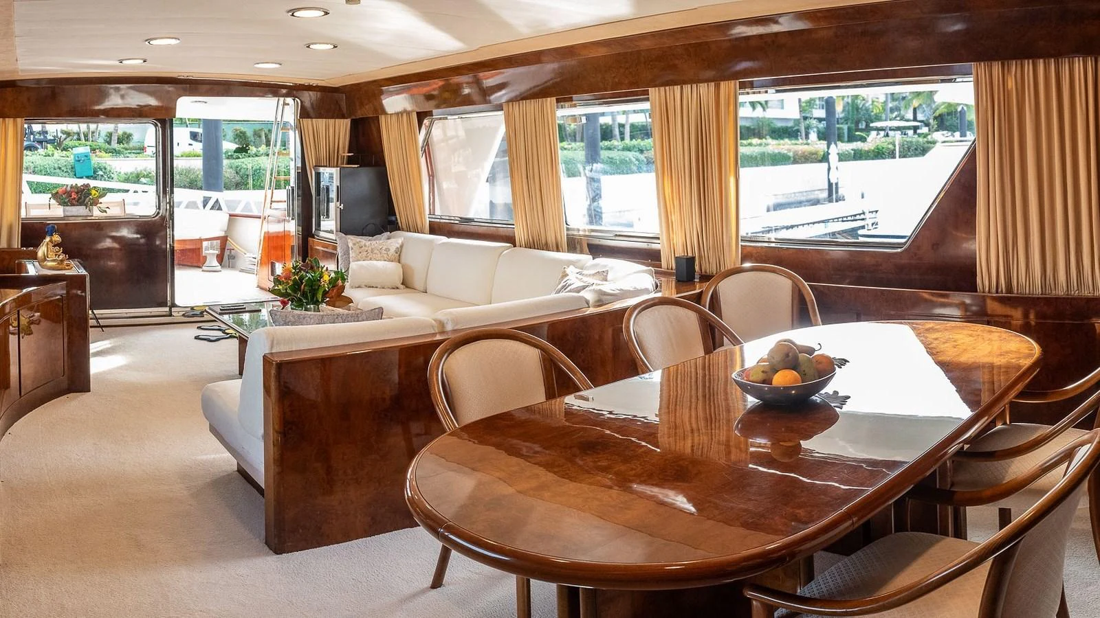 The salon features elegant wood finishes, plush seating, and a dining area with large windows offering scenic views. aboard SISISI Yacht for Sale