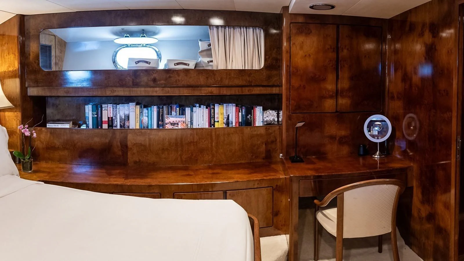 The stateroom features a luxurious wooden desk and a well-stocked bookshelf, creating a cozy and refined atmosphere. aboard SISISI Yacht for Sale