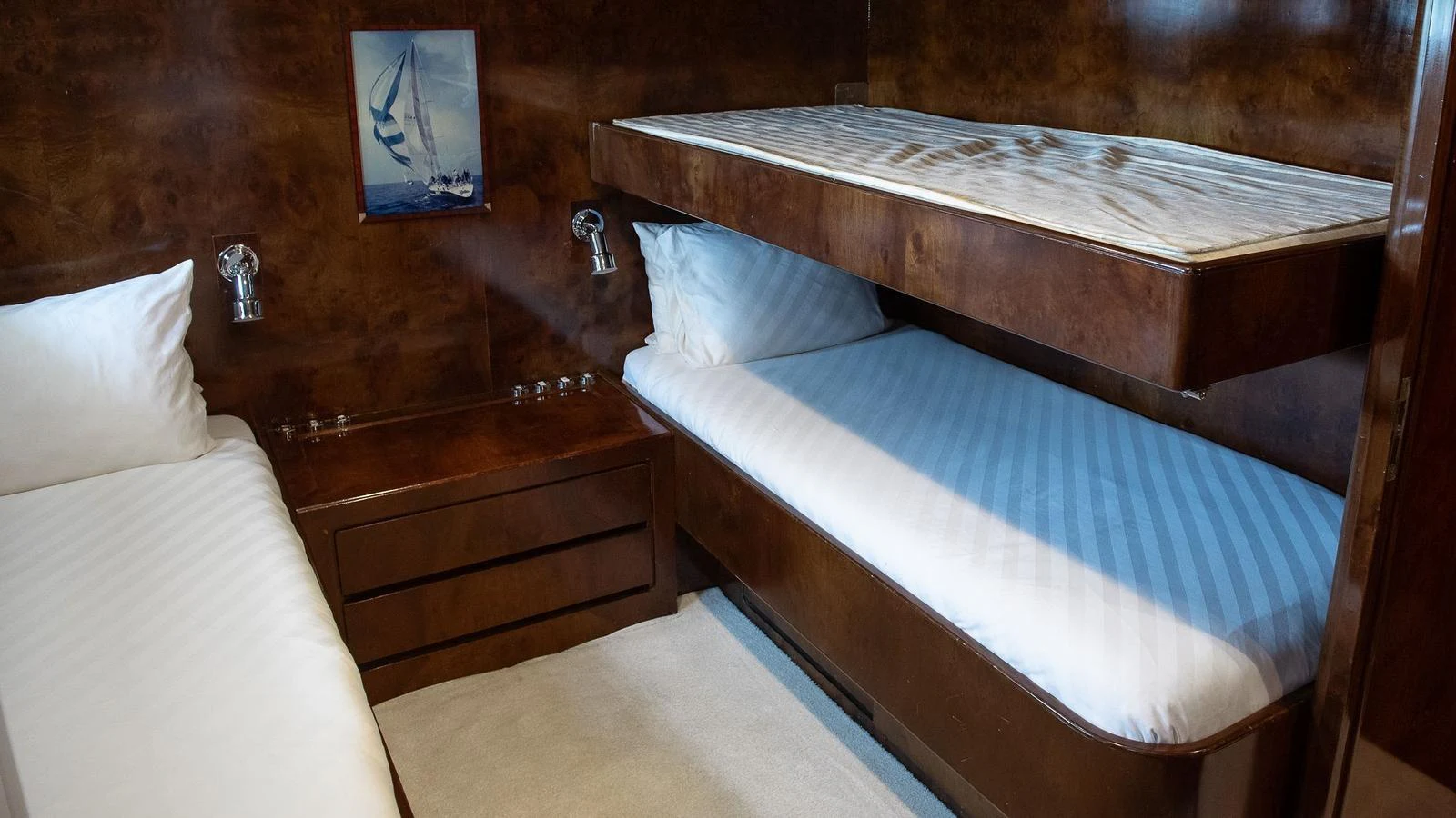 The guest cabin features cozy twin beds with a warm wooden finish and soft lighting. aboard SISISI Yacht for Sale