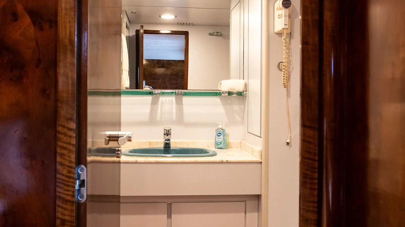 A well-appointed yacht bathroom with a sink, mirror, and wooden accents. aboard SISISI Yacht for Sale