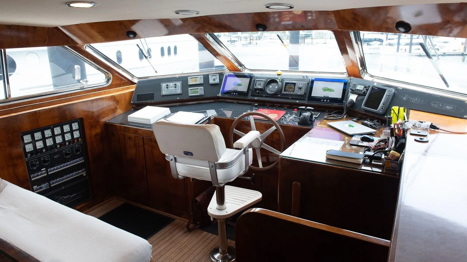 The helm station features advanced navigation equipment and a comfortable captain's chair, set within a polished wooden interior. aboard SISISI Yacht for Sale