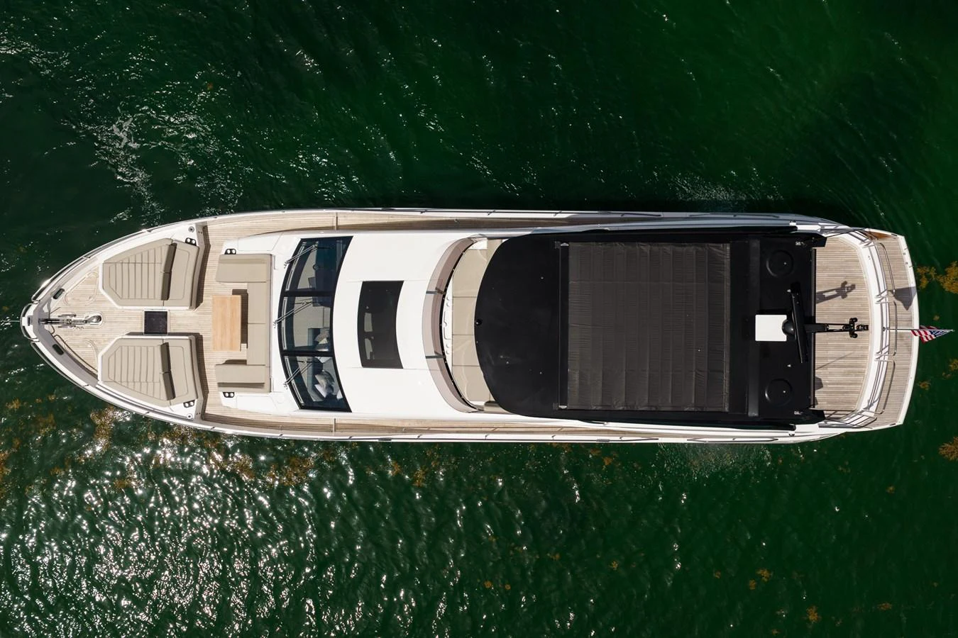 A sleek yacht is captured from above, showcasing its elegant design and spacious deck areas. aboard BAZINGA Yacht for Sale